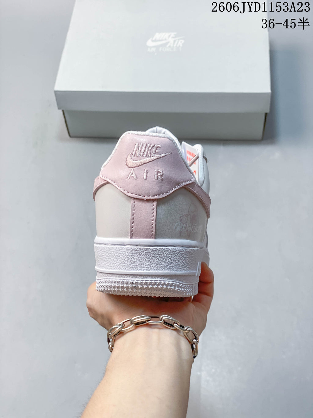Rear view showing pale pink heel trim and a subtle rose motif