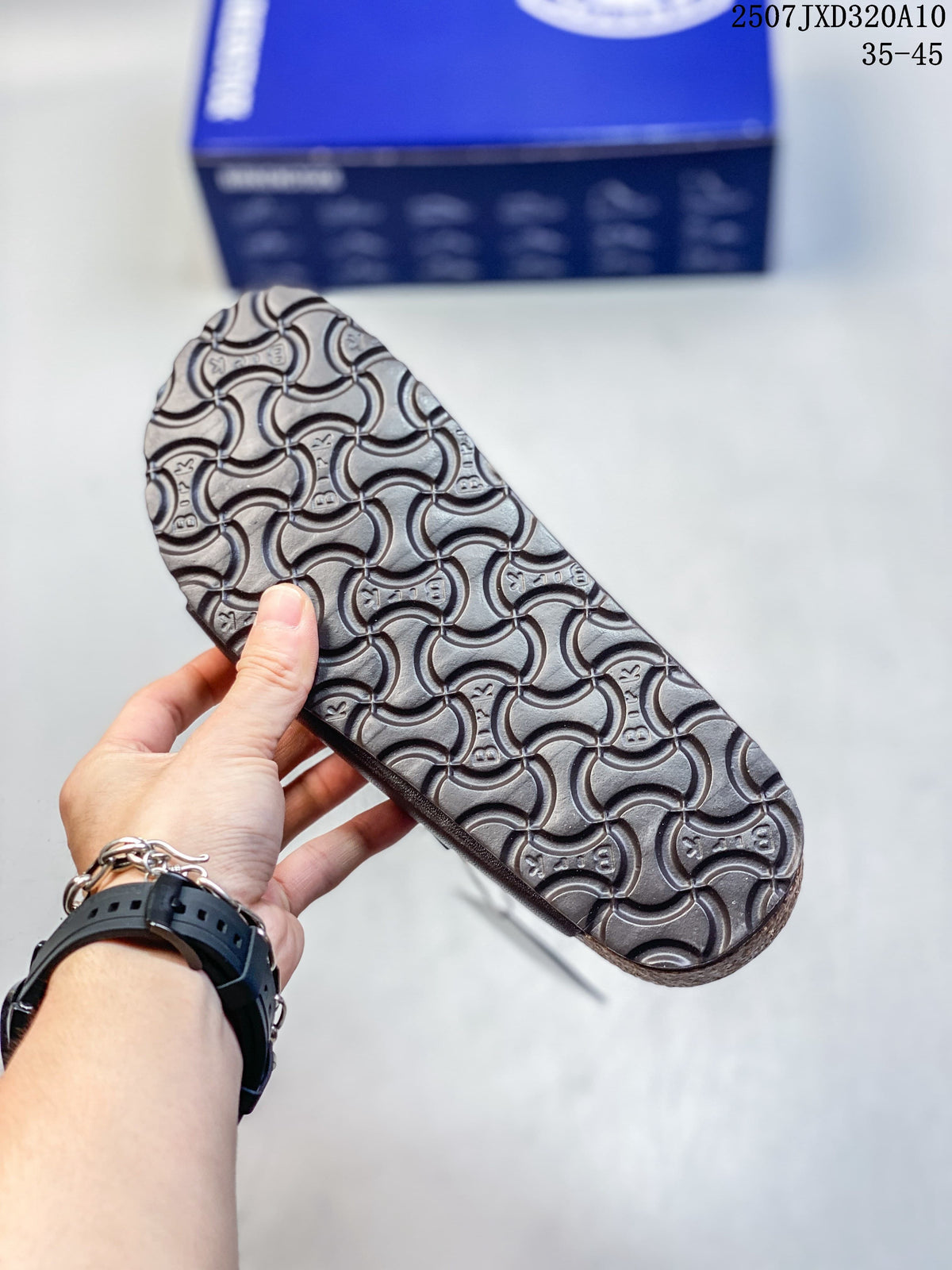 Close-up of the textured outsole on a dark brown slide sandal.