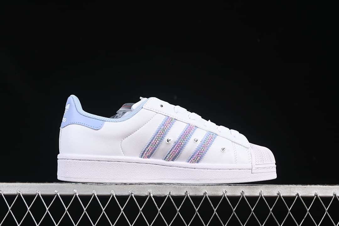 Side view highlighting the pastel stripes, white upper, and light blue heel accent