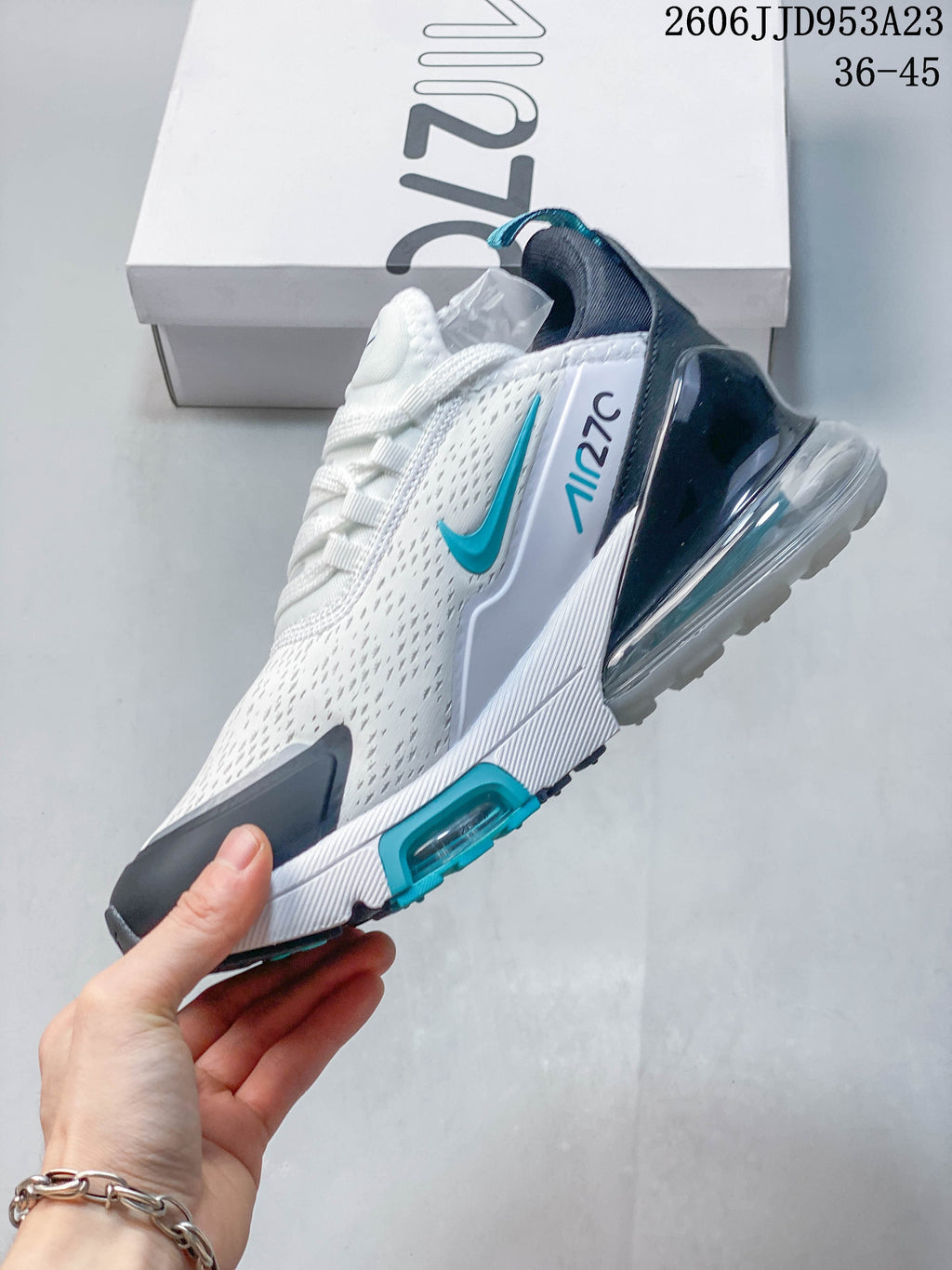 Side view of the white sneaker with teal accents and a visible heel Air Max unit.