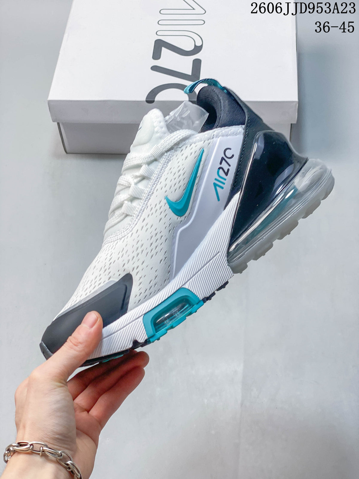 Side view of the white sneaker with teal accents and a visible heel Air Max unit.