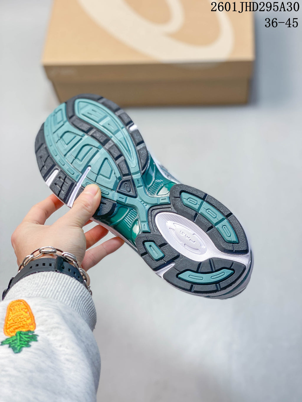 Underside view showing the teal, white, and dark outsole