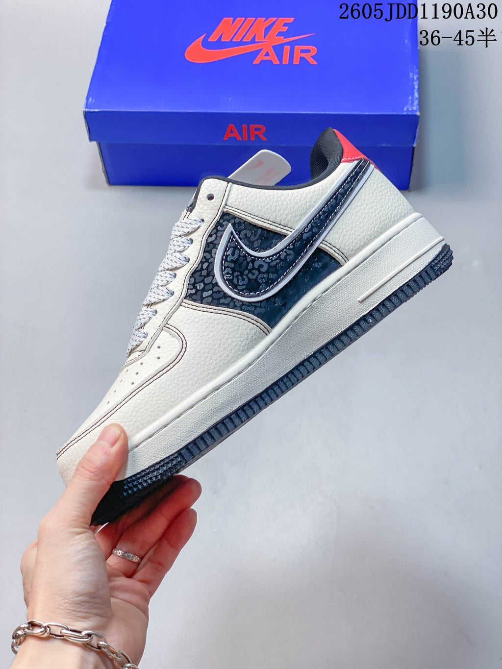 Side profile showing the patterned navy panel, Swoosh detail, and ivory upper