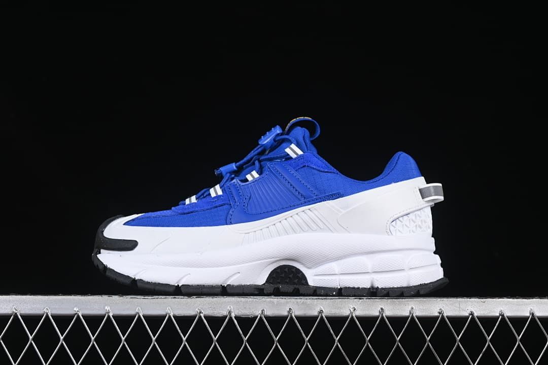 Side profile of a blue Nike Zoom Vomero Roam sneaker with a chunky white midsole