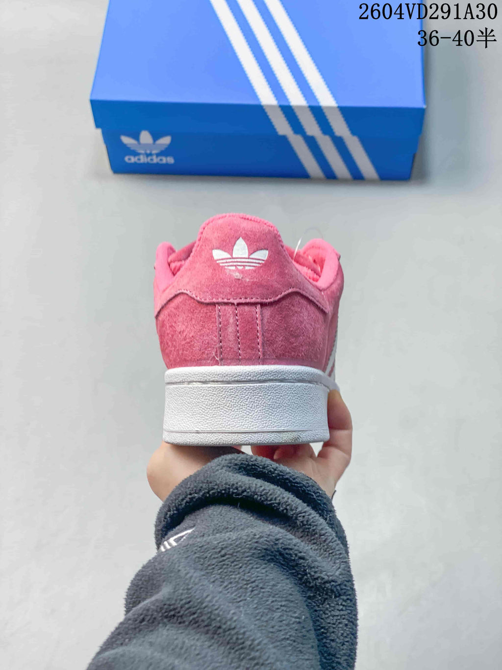 Rear view of the pink sneaker with a white midsole and heel logo.