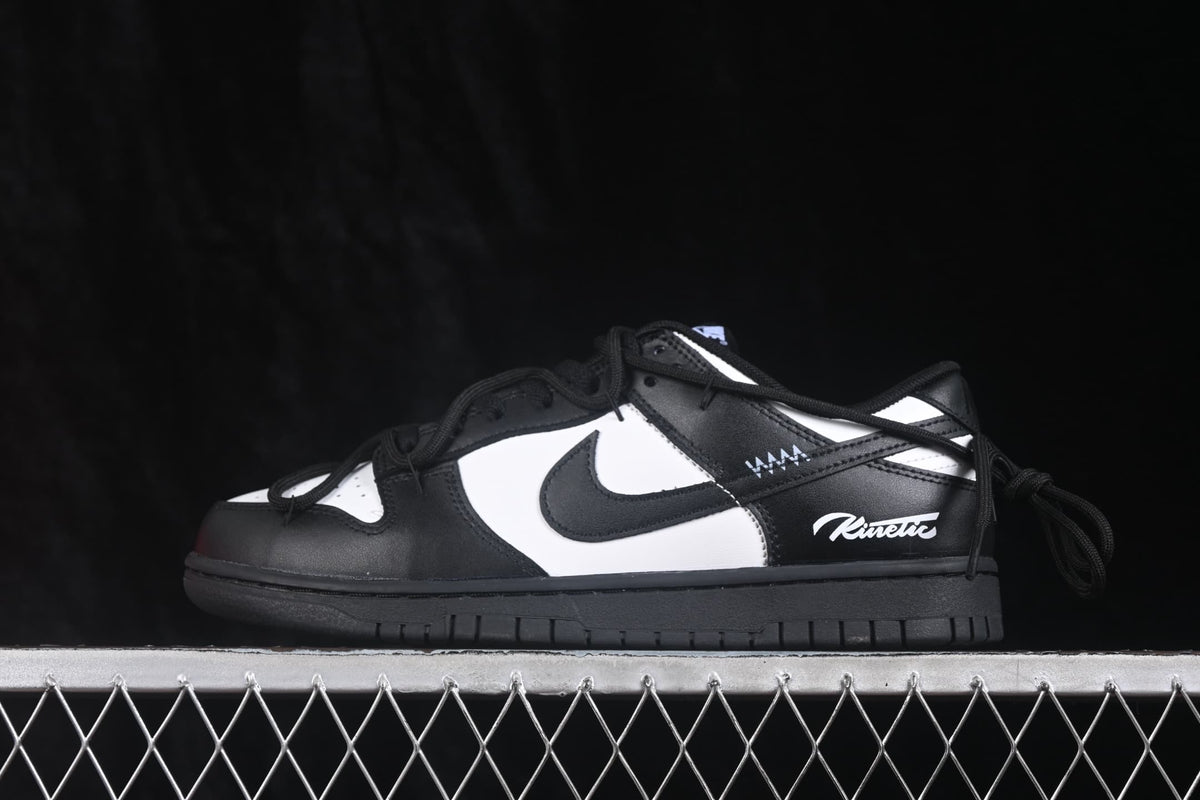 Side profile of a black and white low-top sneaker showing the black Swoosh, white mid-panel, black laces, and printed side branding.