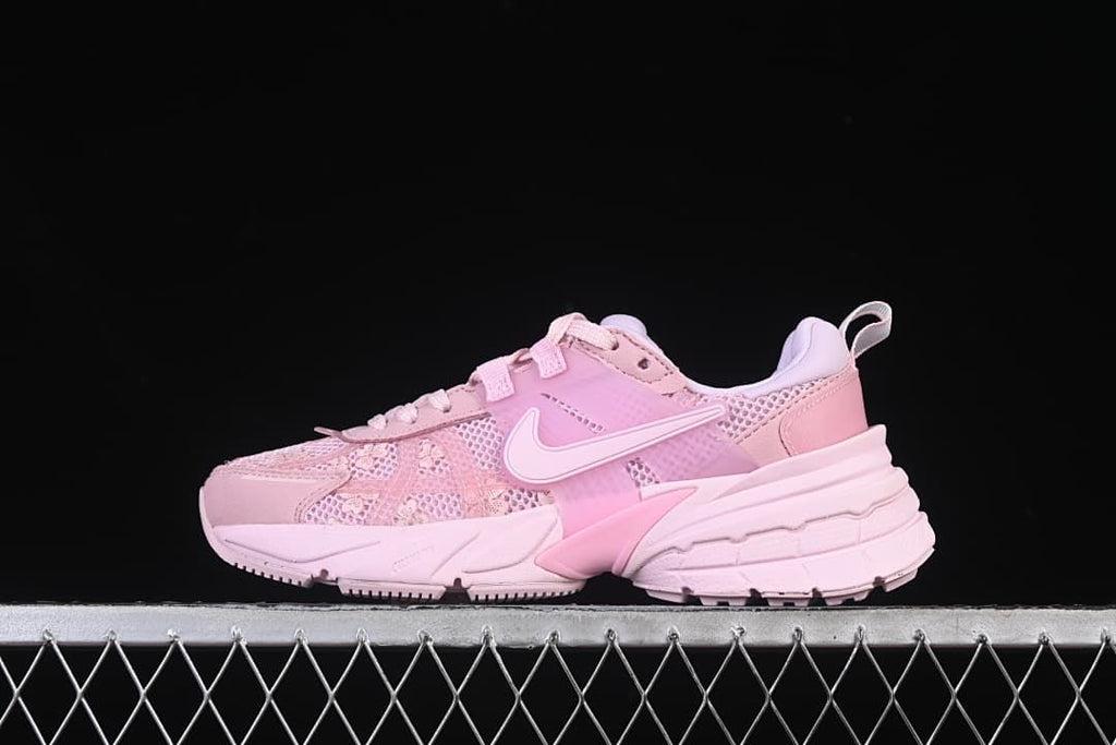 Side view of the pink Nike V2K Run sneaker against a dark background.