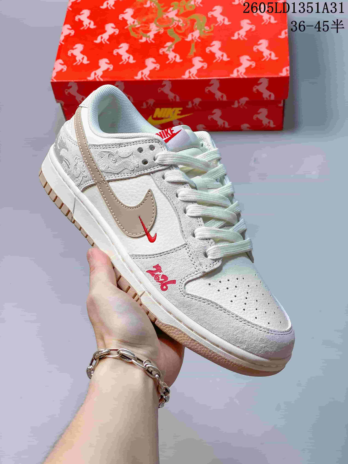 Angled close-up showing embroidered details, a taupe Swoosh, and red decorative accents