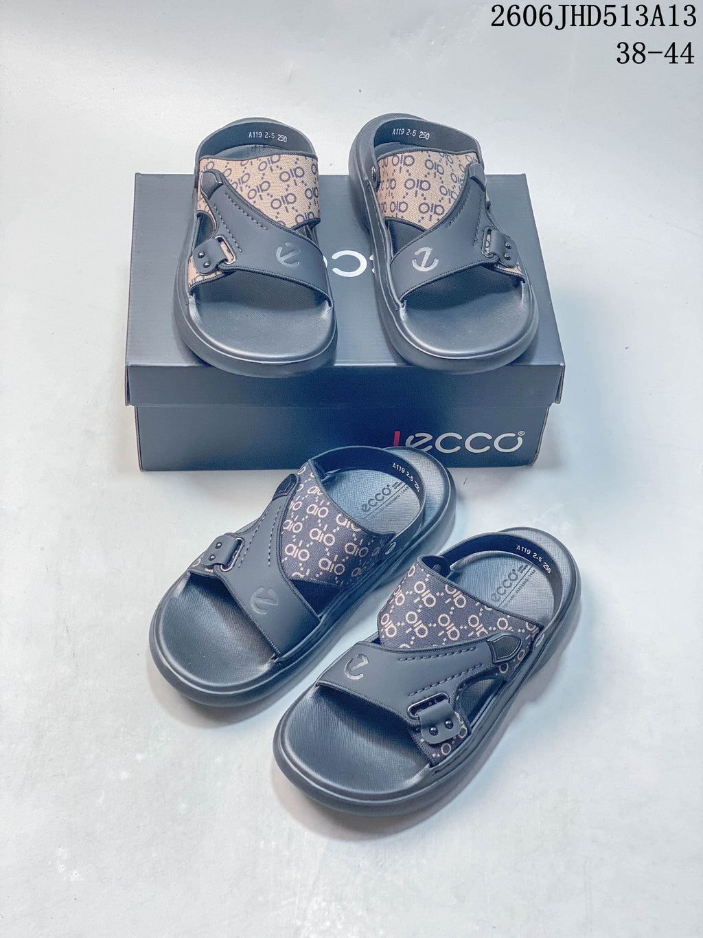 Several views of gray patterned slide sandals arranged on and in front of a branded box.