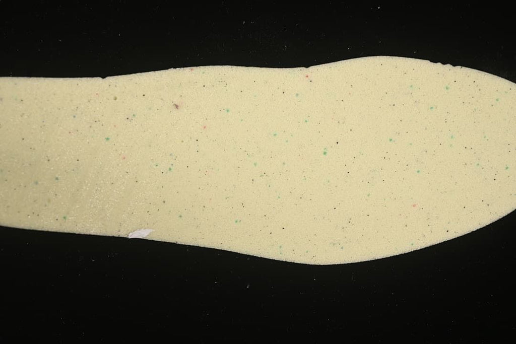 Close-up view of a light-colored shoe insert shown separately.