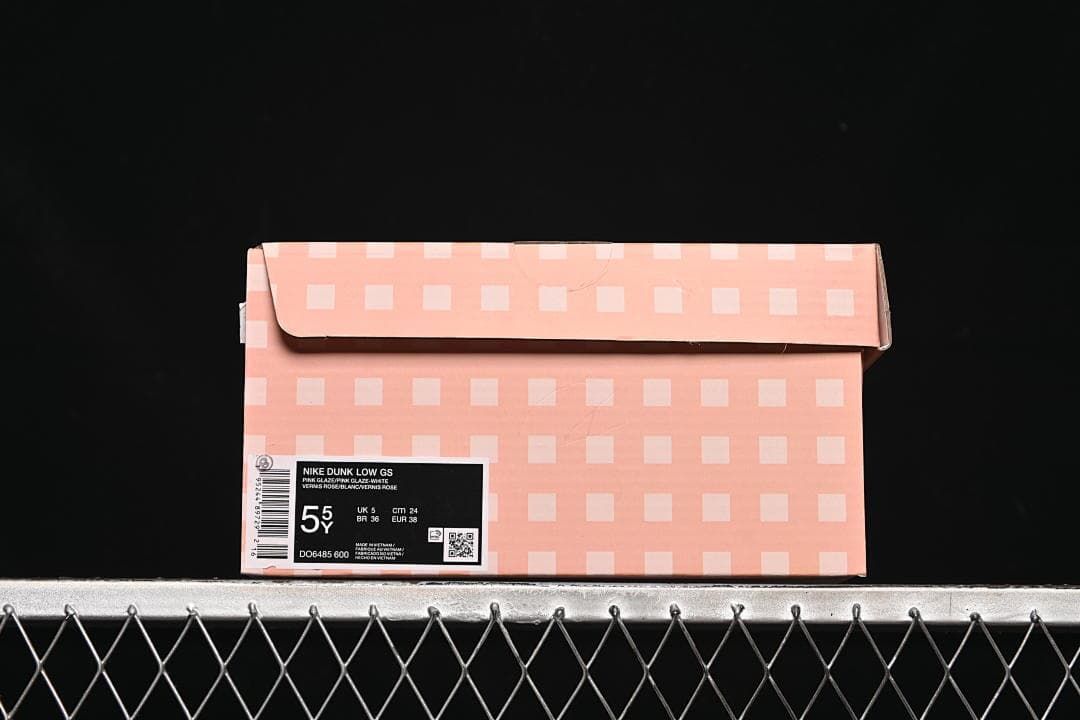 Pink patterned shoe box labeled Nike Dunk Low GS, with a sample size and style code.
