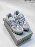 Pair of silver-gray New Balance 997 1954 Series sneakers on a shoebox.