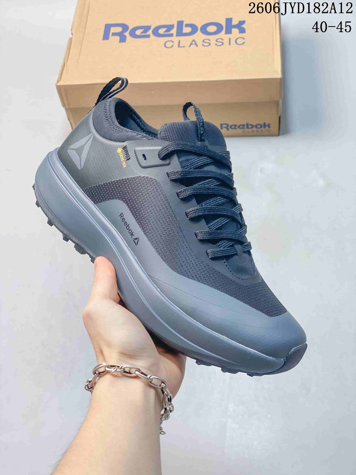 Angled side view of the grey Reebok sneaker with visible side branding