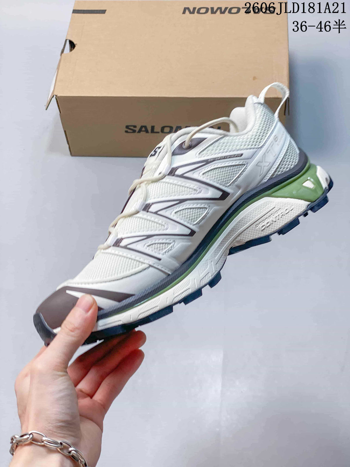 Side view of the sneaker with layered panels, dark accents, and green midsole detail.