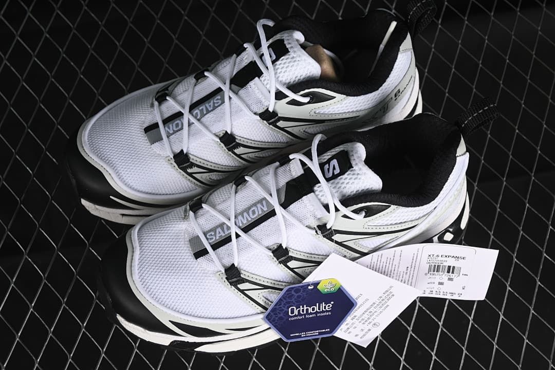 Pair of white, metal, and black XT-6 Expanse sneakers with tags.