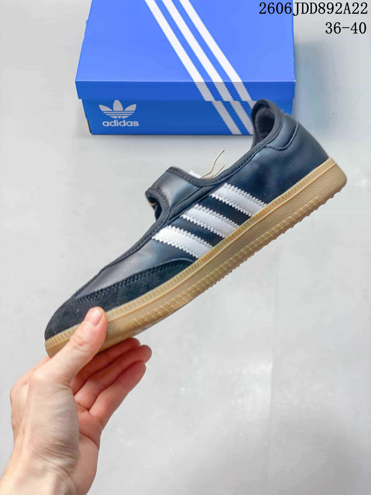 Side view of a black adidas Samba Jane sneaker with white stripes and a gum-color outsole.