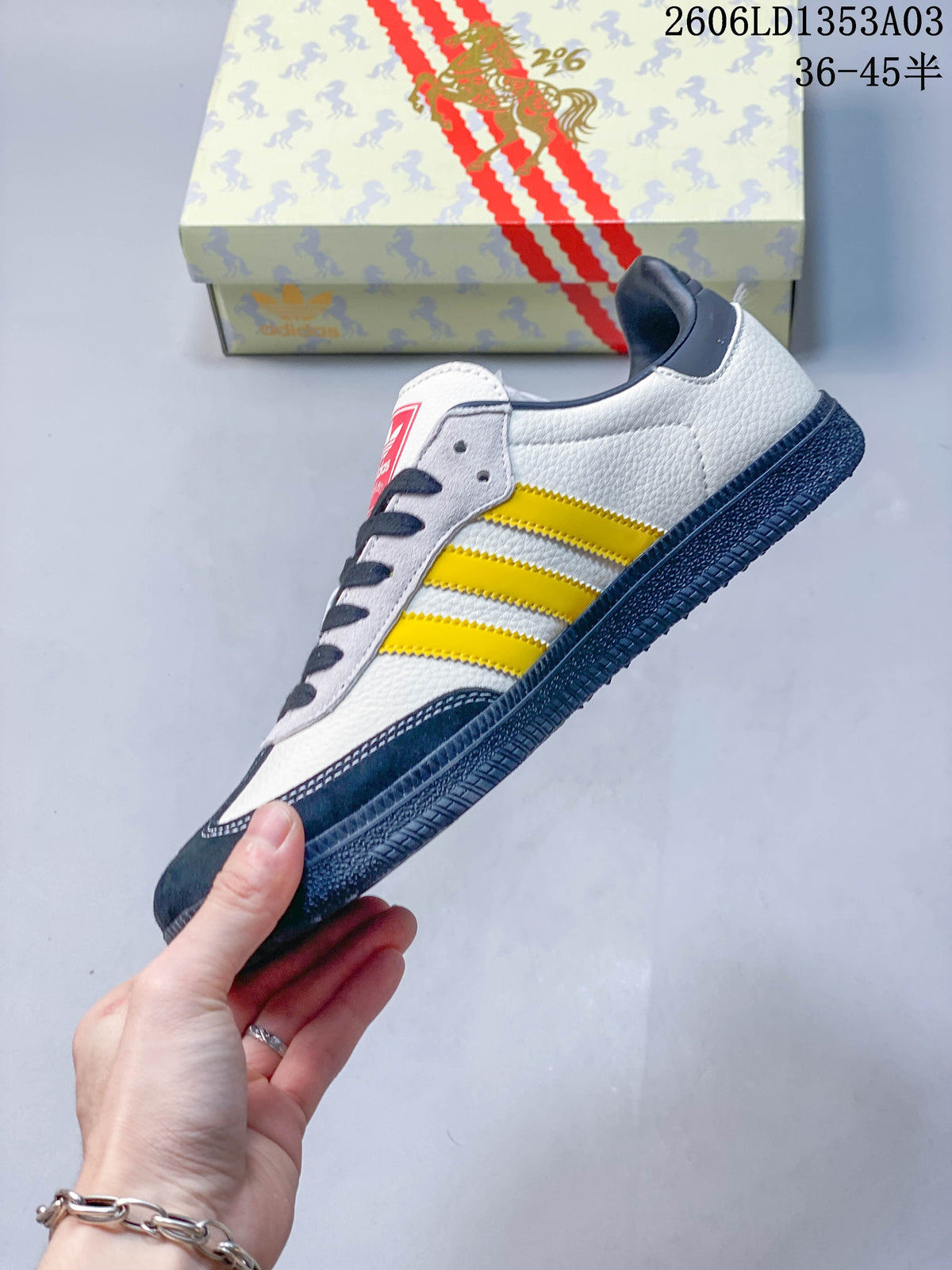 Side view of the white sneaker with yellow stripes, navy overlays and horse-themed detailing.