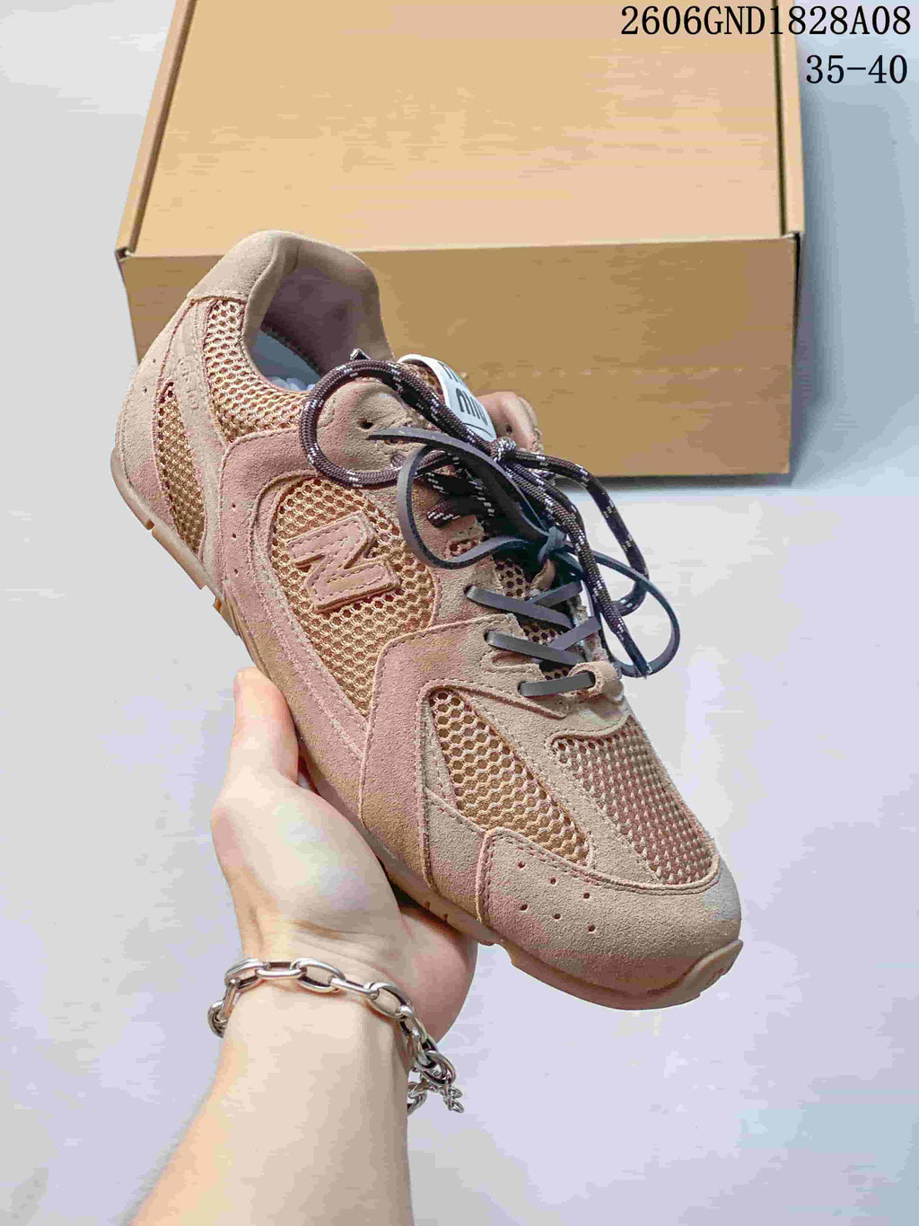 Angled side view of the rose-beige sneaker with mesh panels and a side logo.