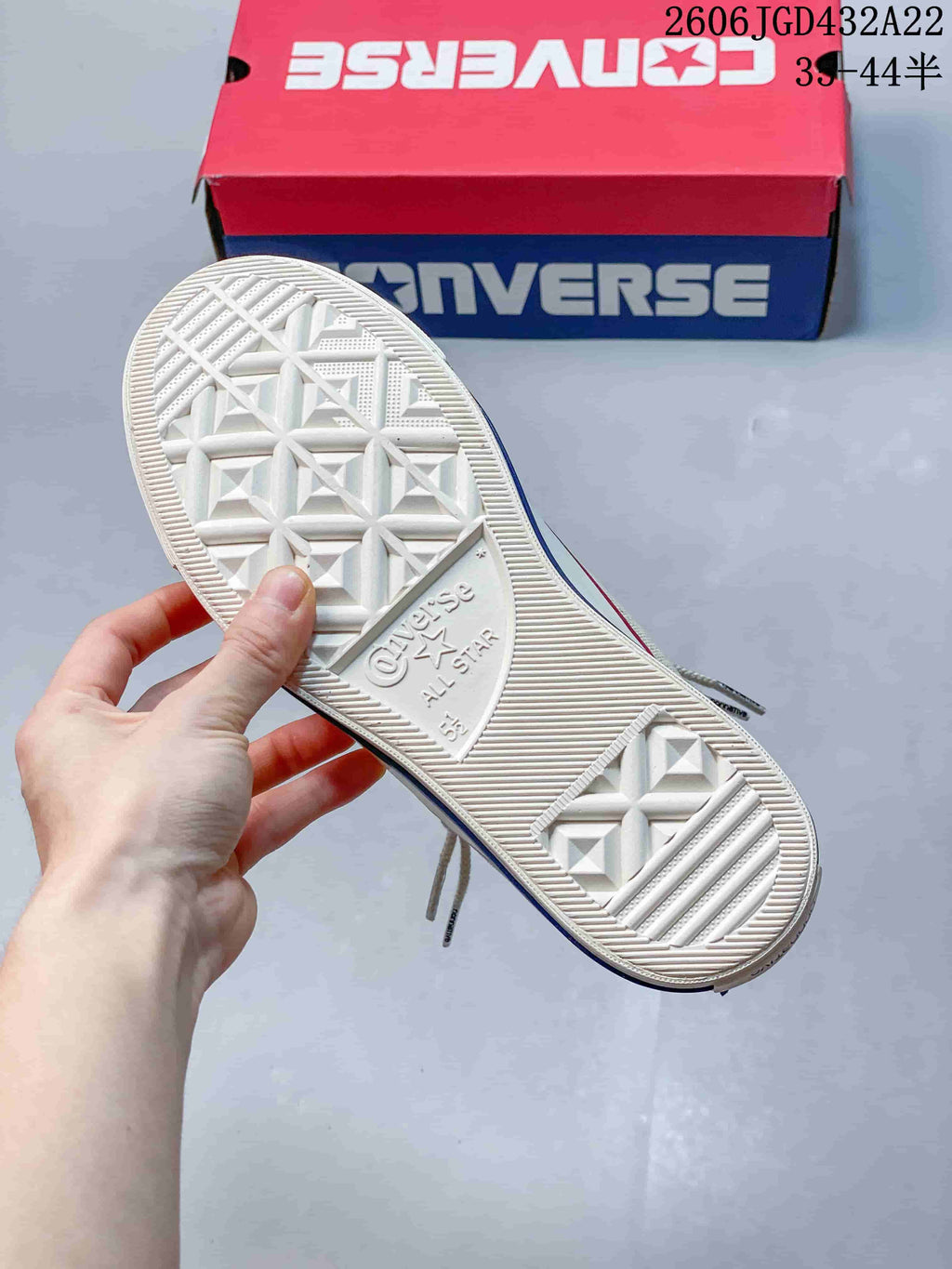Underside of a white Converse All Star sneaker showing the patterned rubber outsole