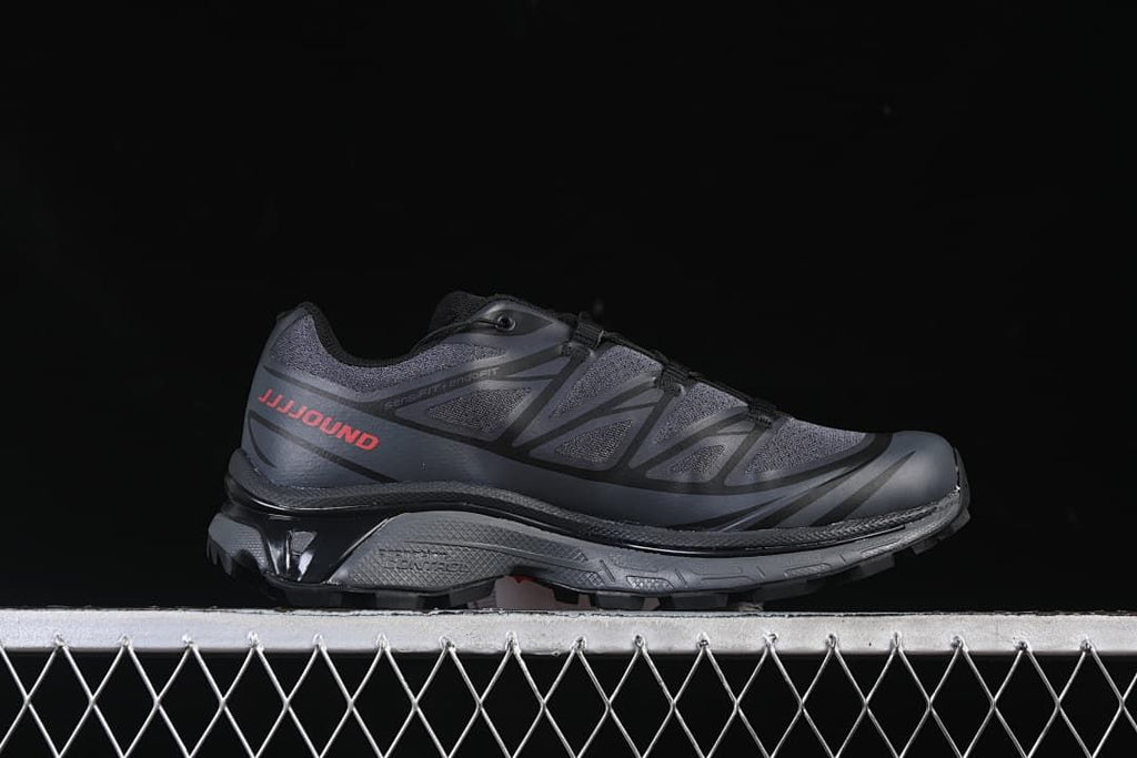 Side profile of a dark gray shoe with JJJJound lettering