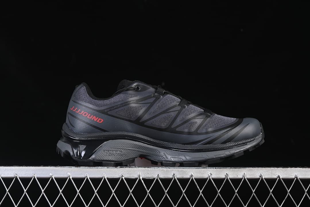 Side profile of a dark gray shoe with JJJJound lettering