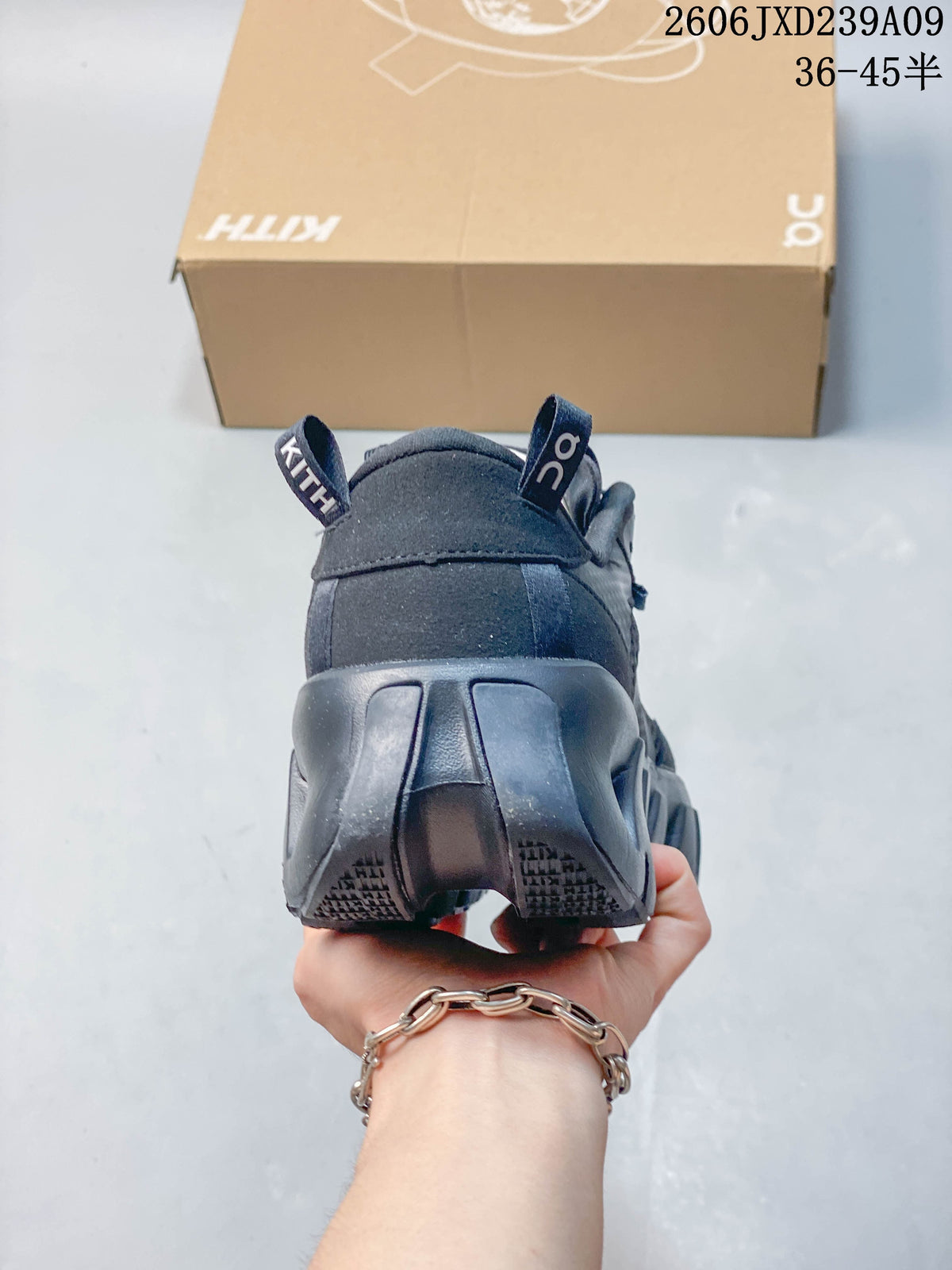 Rear view showing the heel and sculpted sole of a charcoal shoe.