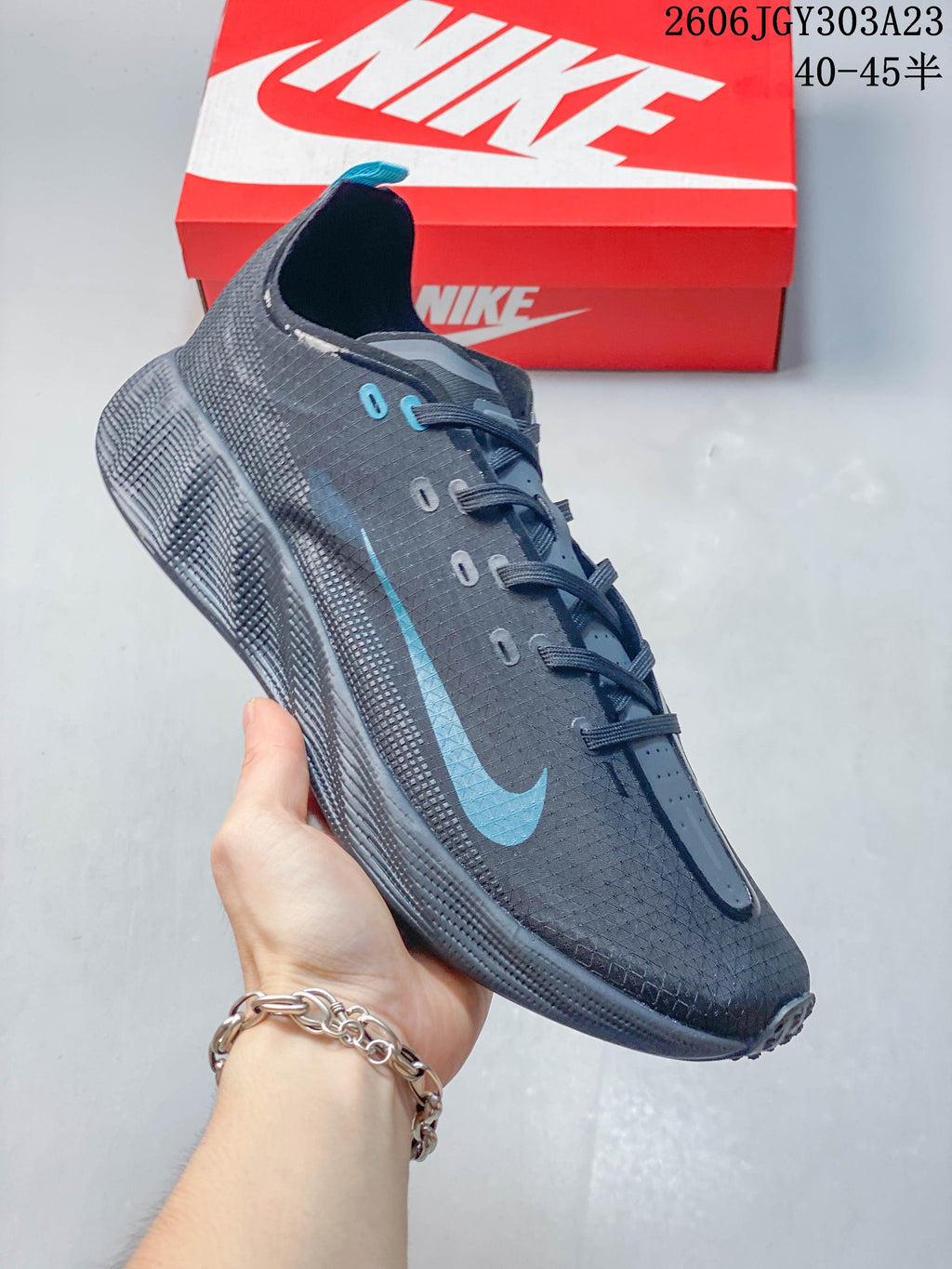 Side view of a charcoal gray Nike Ava Rover shoe with blue accents and a textured sole.