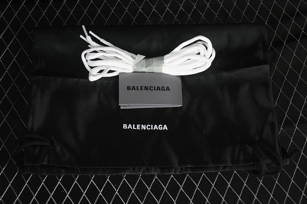 Black drawstring bag and spare white laces shown with the sneakers