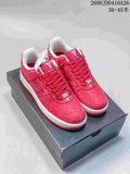 Red low-top Nike Air Force 1 '07 sneakers with a textured upper and white midsole, displayed on a shoe box.