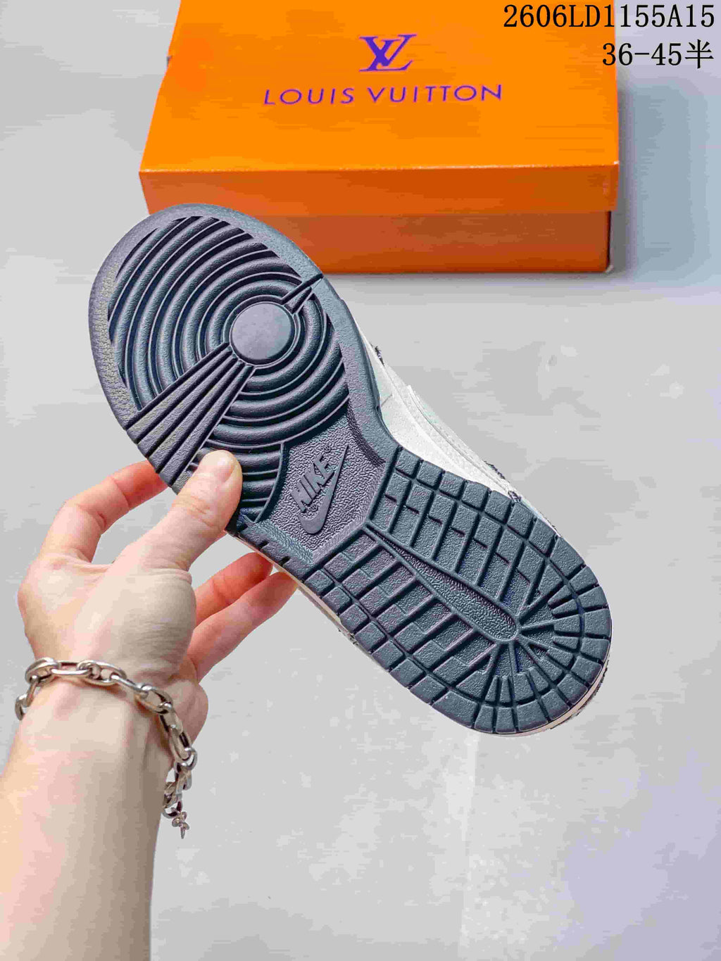 Close-up of the dark patterned rubber outsole and orange shoebox