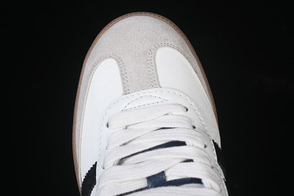 Top-down close-up of the gray toe overlay and white laces.