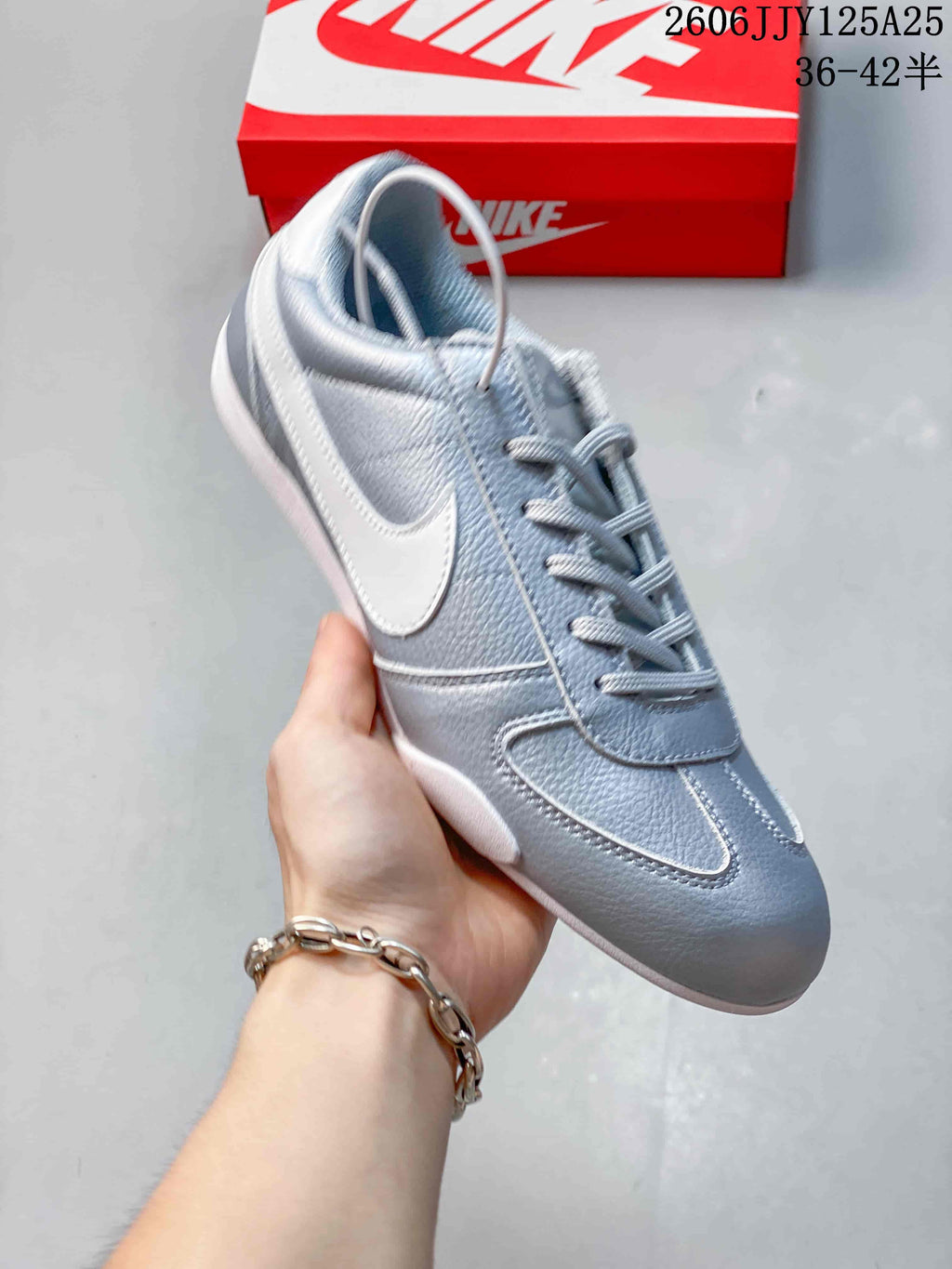 Side view of a metallic silver Nike Sprint Sister sneaker with a white Swoosh