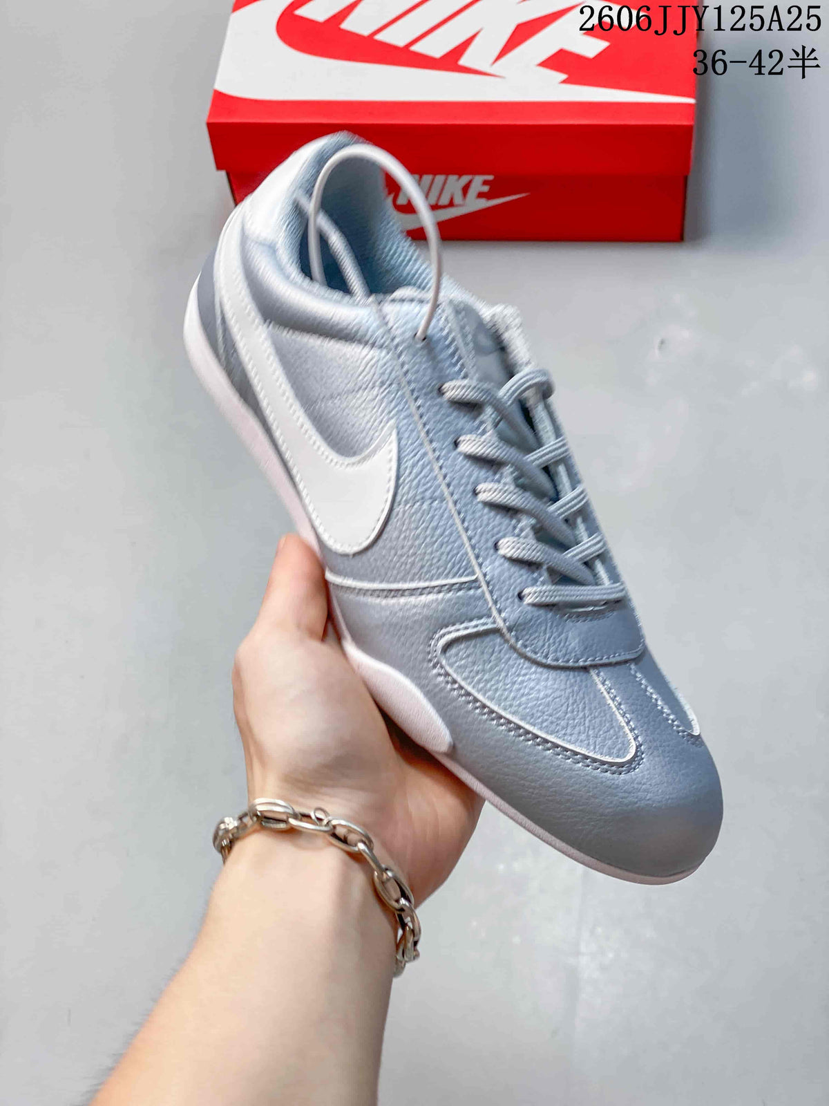 Side view of a metallic silver Nike Sprint Sister sneaker with a white Swoosh