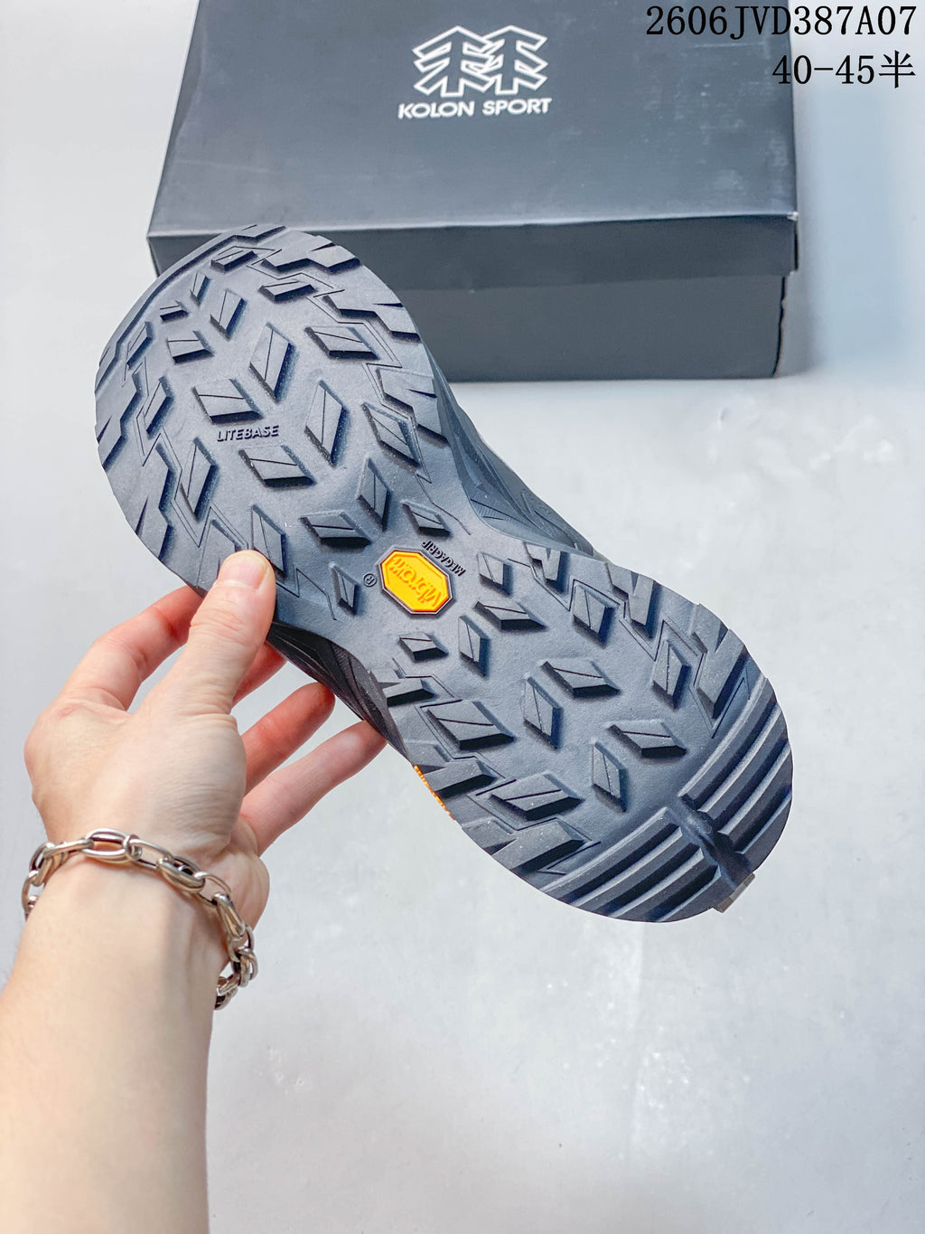Close-up of the sneaker outsole showing its patterned tread and the Kolon Sport shoebox