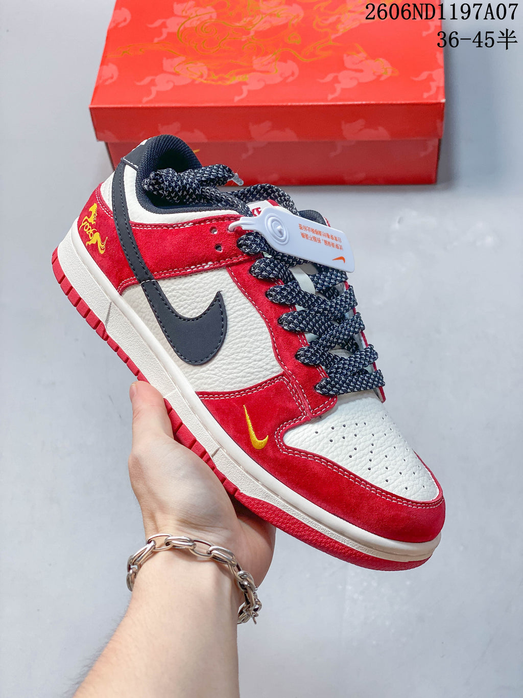 Close view of a red, white, and navy low-top sneaker with a dark Swoosh, patterned laces, and small yellow accents.