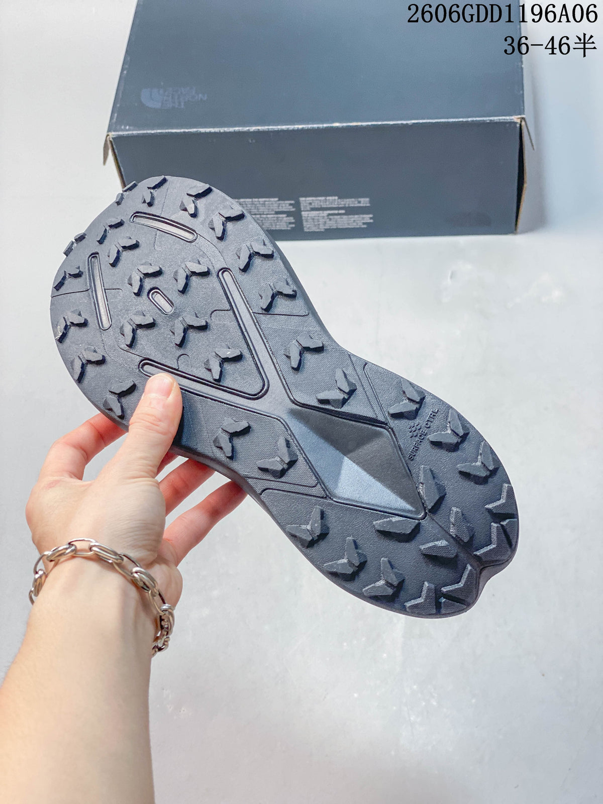 Close-up of the lugged outsole on a gray trail shoe