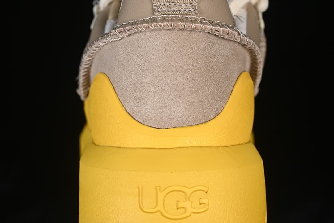 Rear view showing the taupe heel, yellow sole, and embossed UGG logo