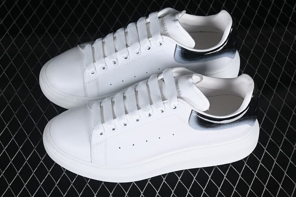 Pair of white low-top sneakers with gradient heel tabs