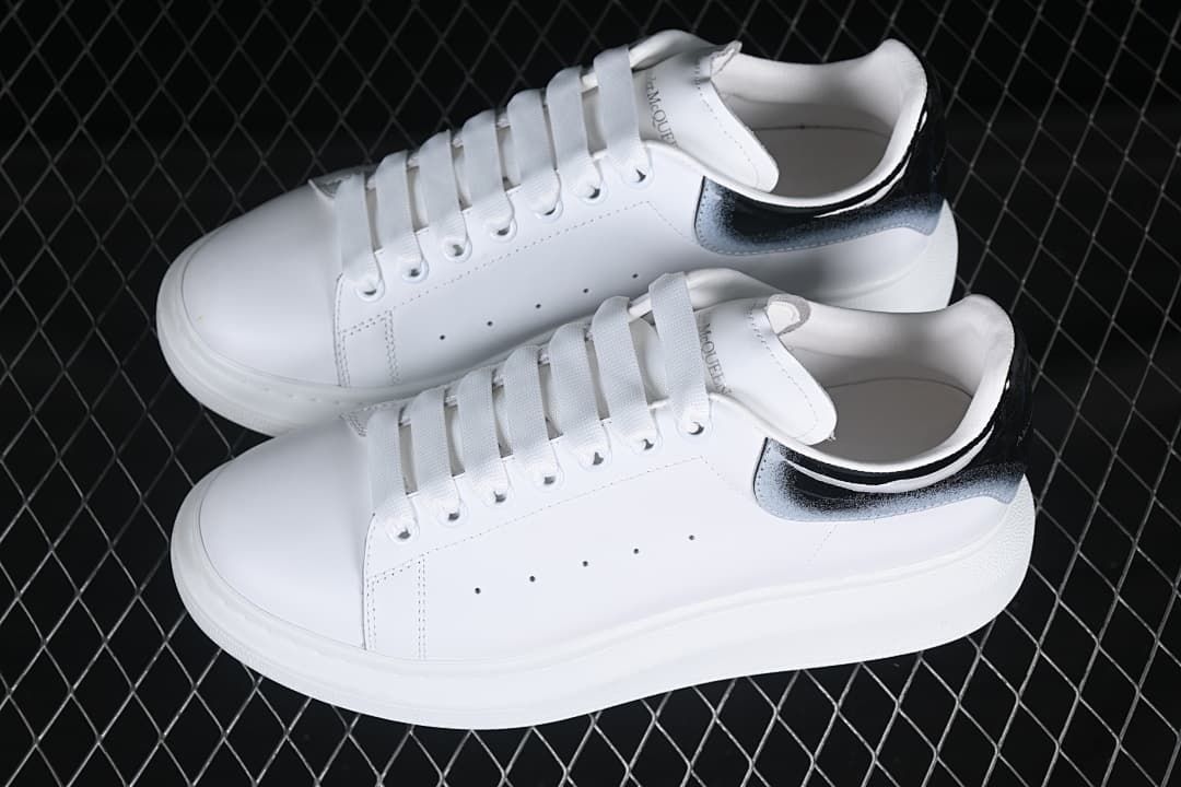 Pair of white low-top sneakers with gradient heel tabs