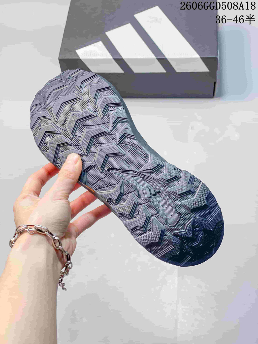 Close-up of the patterned outsole on a gray trail running shoe