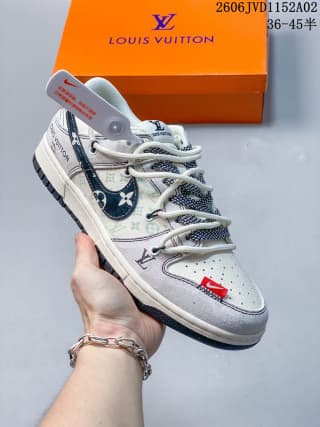 Angled view of the white and gray Louis Vuitton x Nike Dunk Low sneaker showing the patterned side panel, perforated toe, and red accent.