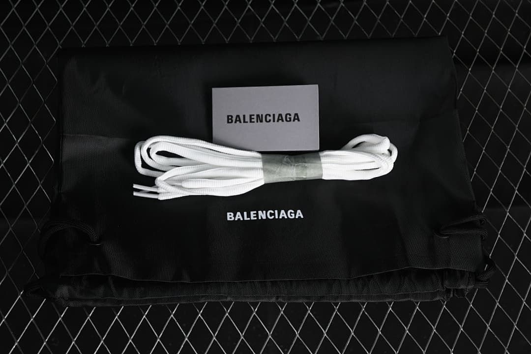 Black shoe bag, card and extra white laces shown with Balenciaga branding.