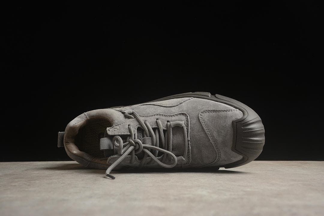 Top view of a gray sneaker showing the laces and stitched upper panels.