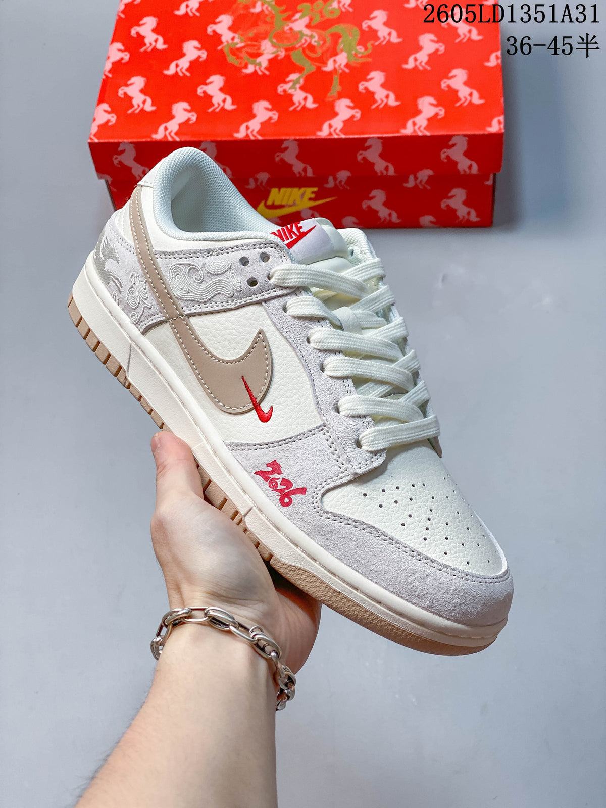 Close view of an off-white and taupe Nike Dunk Low with embroidered panels and red accents