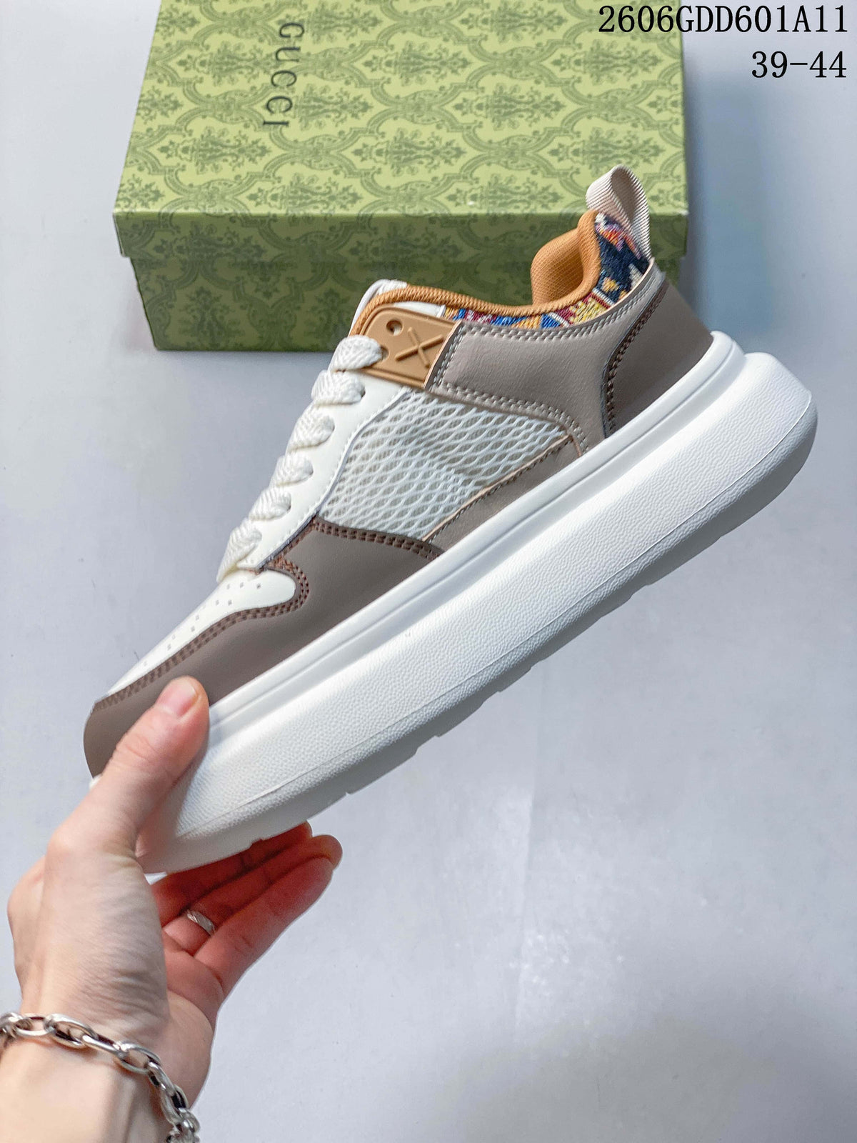 Side view of a white and taupe low-top sneaker with mesh inserts