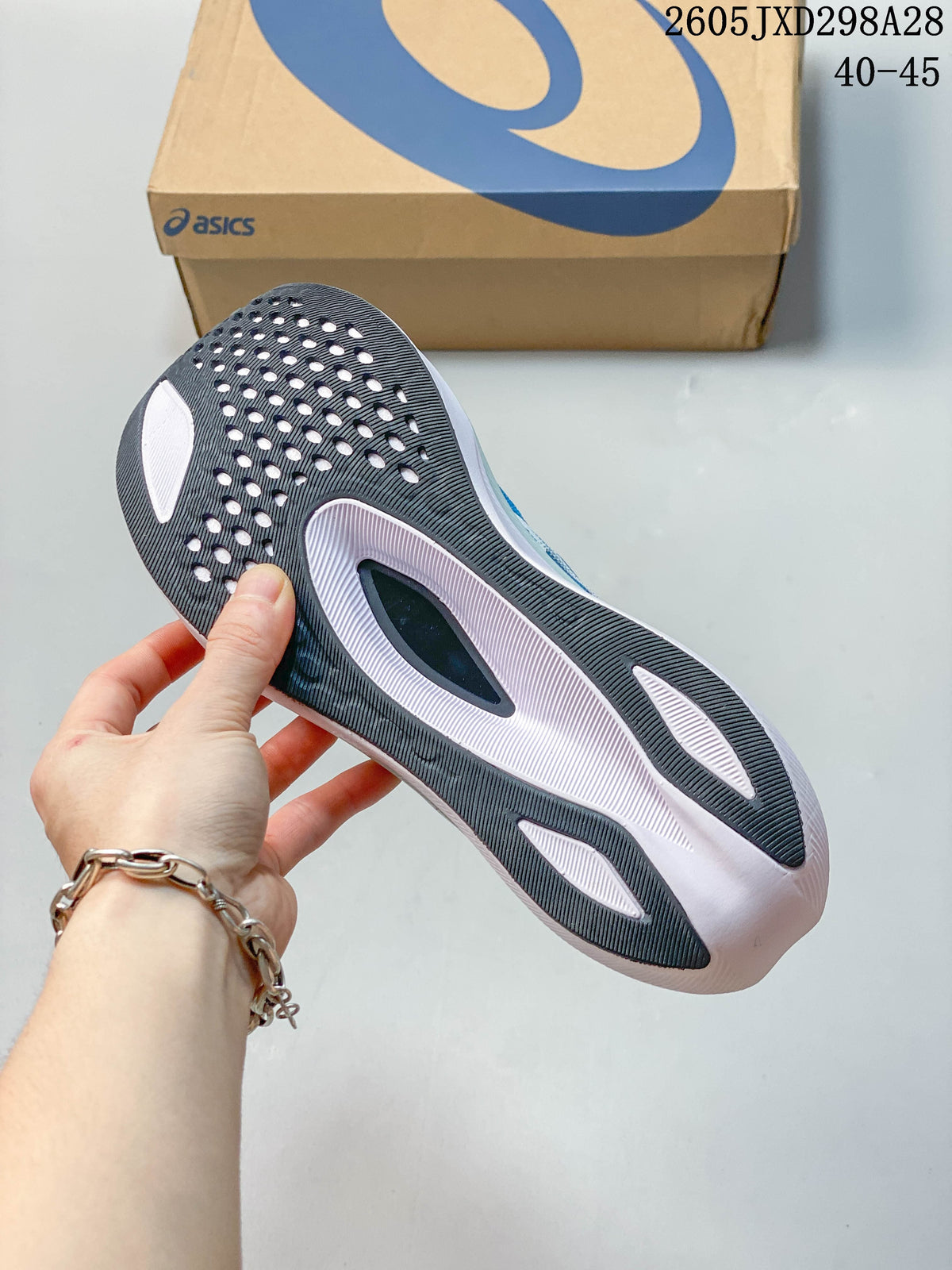 Close-up of the dark patterned outsole on an ASICS Magic Speed 4 shoe
