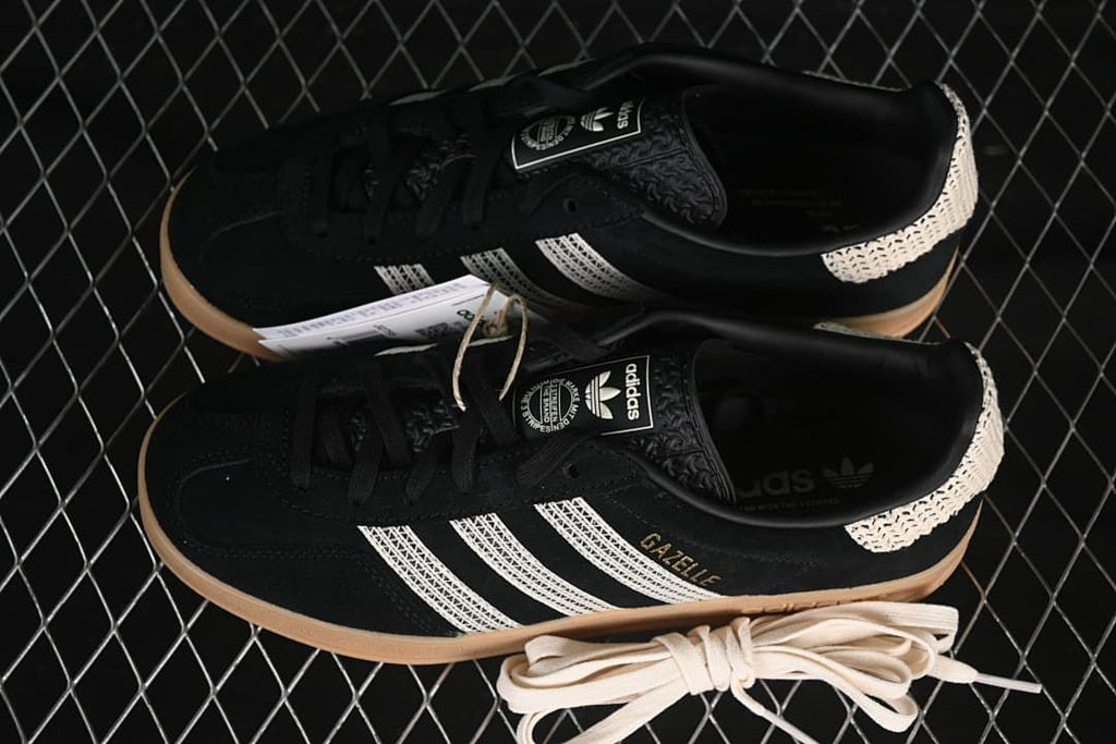 Pair of black Gazelle Indoor sneakers with cream stripes and gum-colored soles.