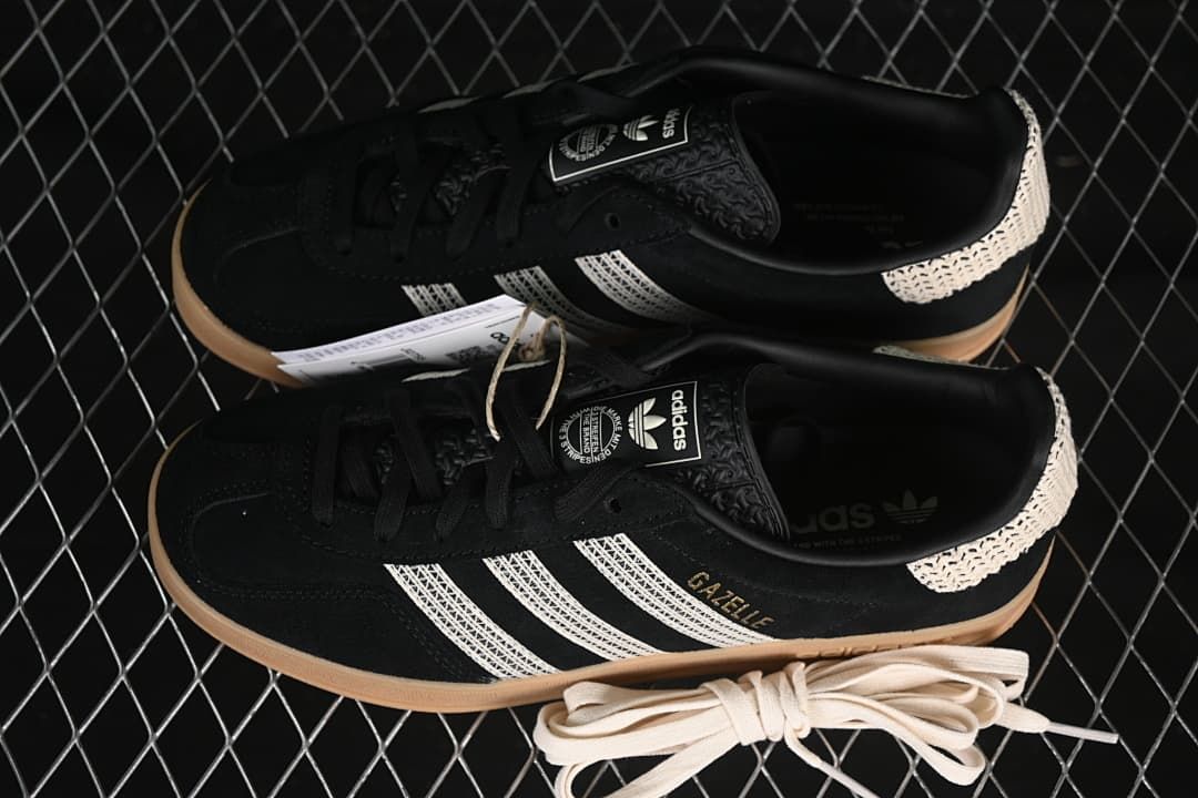 Pair of black Gazelle Indoor sneakers with cream stripes and gum-colored soles.
