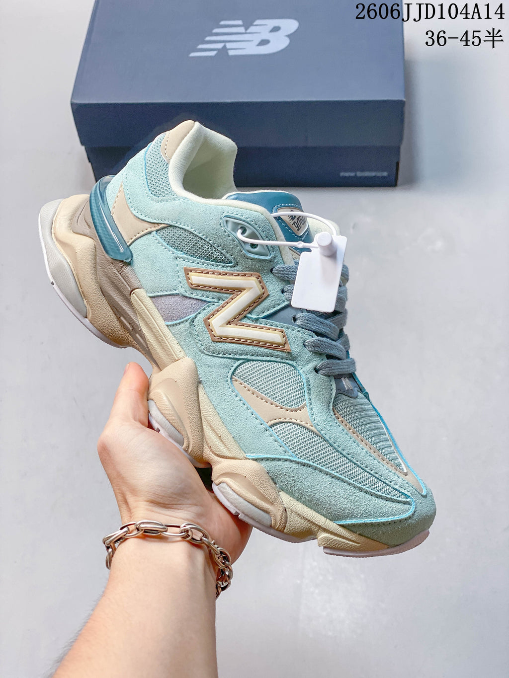 Light blue and cream New Balance 9060 sneaker with mesh panels and a sculpted sole.