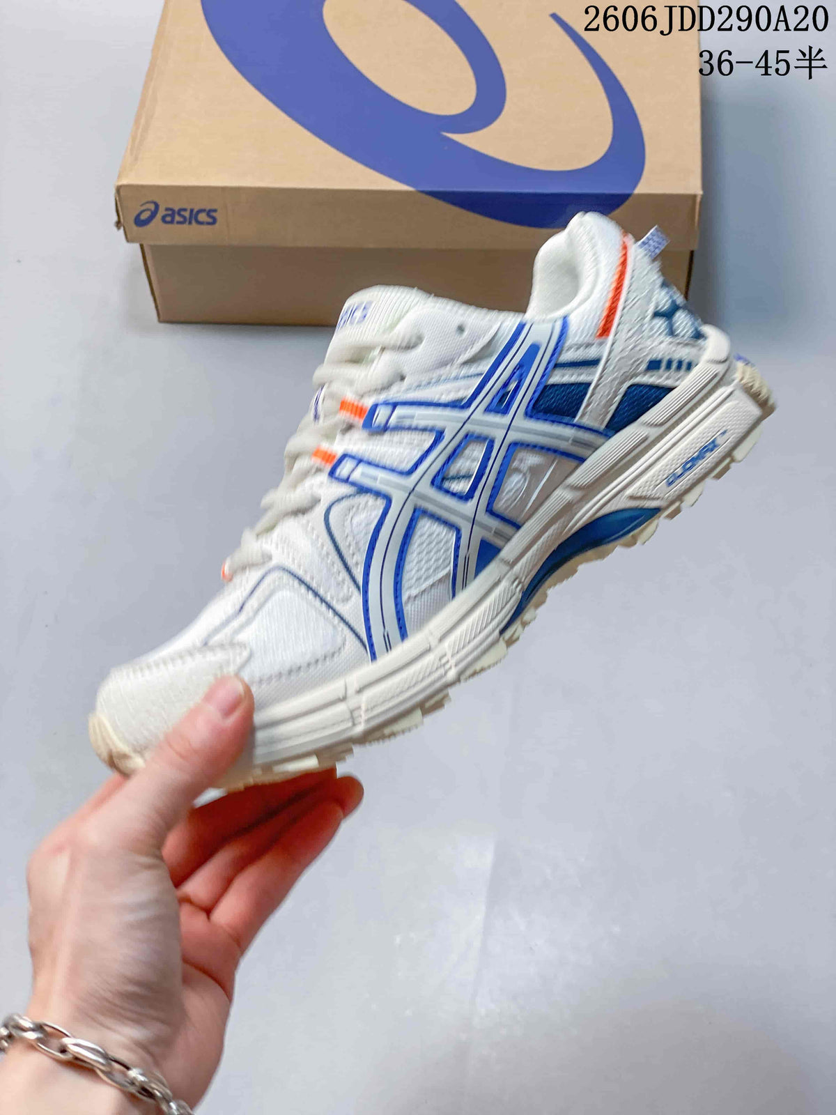 Side profile of a white ASICS sneaker with blue overlays and orange accents.